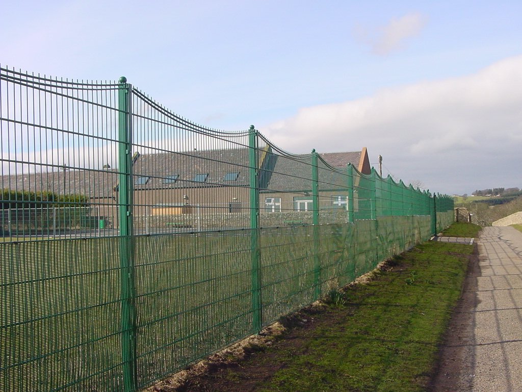 A decorative wave top panel system installed around a primary school playing field.