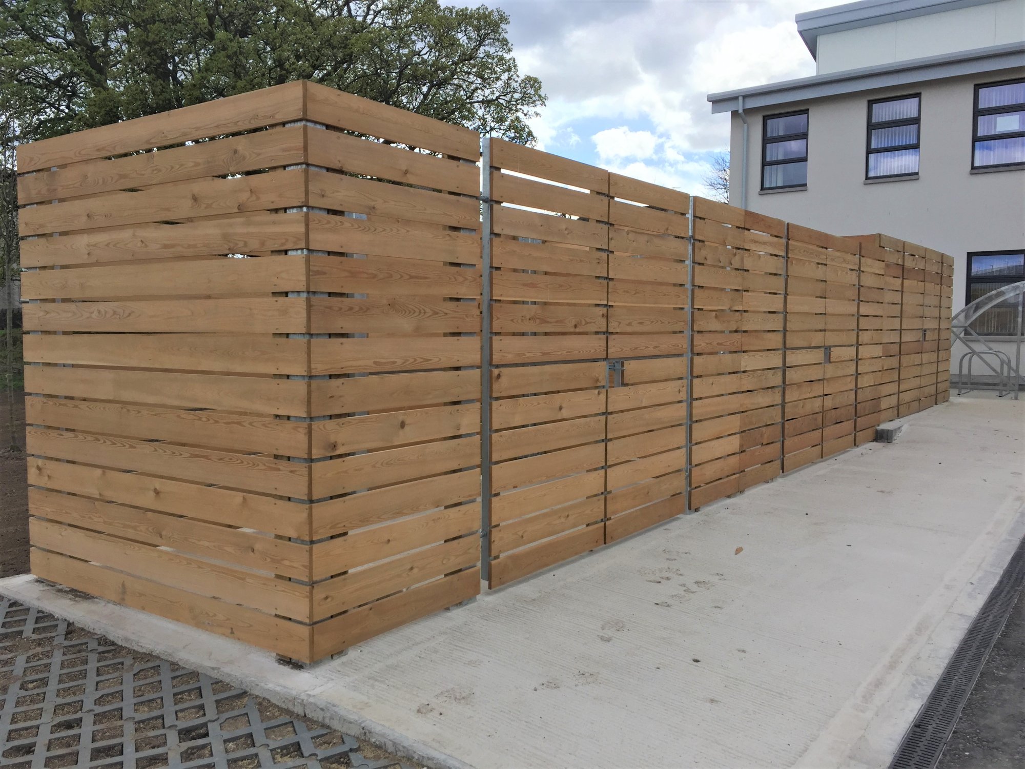 Bin store enclosures formed in galvanised SHS posts and horizontal slats.